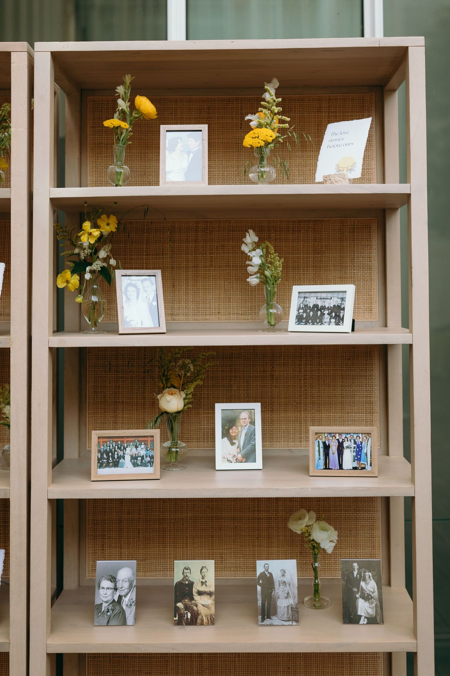 Wedding photo display shelf with yellow flowers and framed memories arranged on multiple tiers.