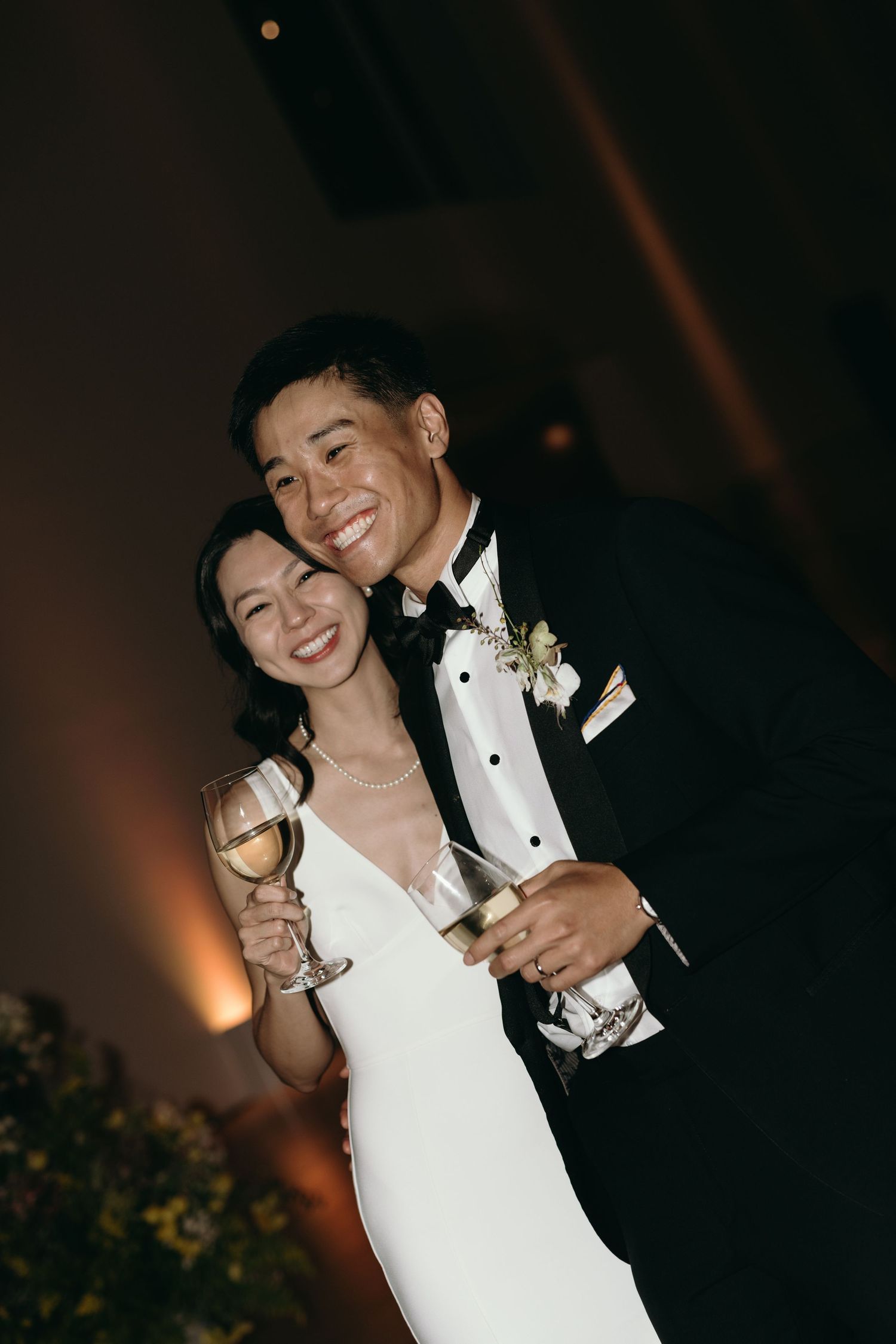 Joyful wedding reception moment captured in warm lighting.