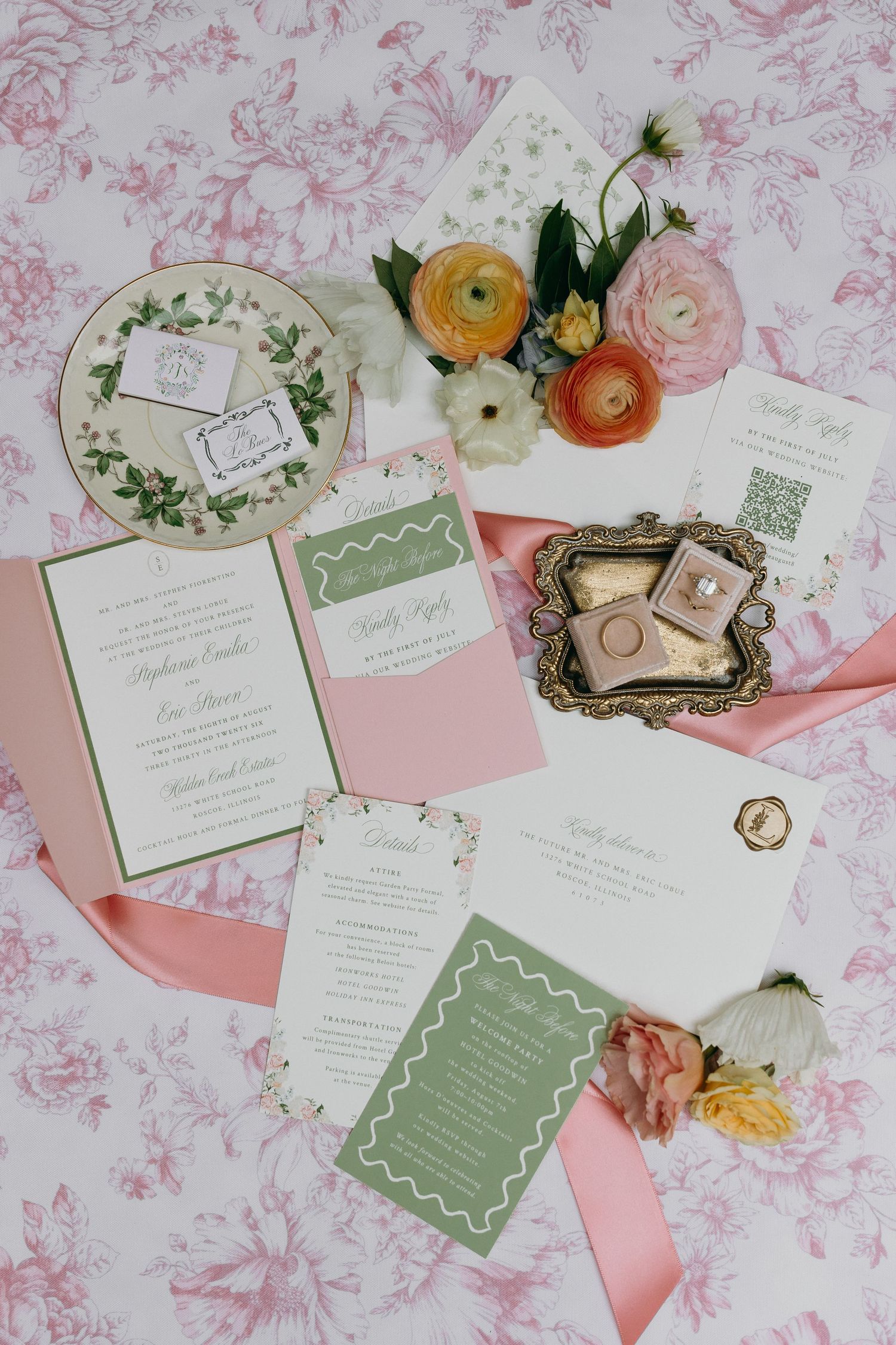 Elegant wedding invitation suite in pink and green with floral accents, ranunculus blooms, and gold ring box on toile fabric.