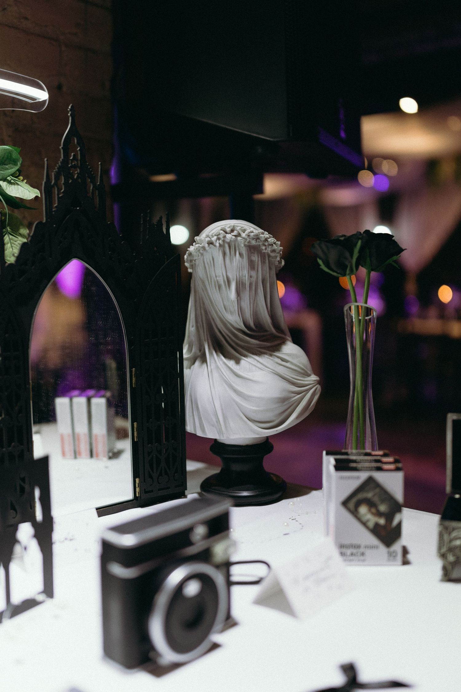 Wedding reception decor featuring vintage cameras and artistic lighting arrangements.