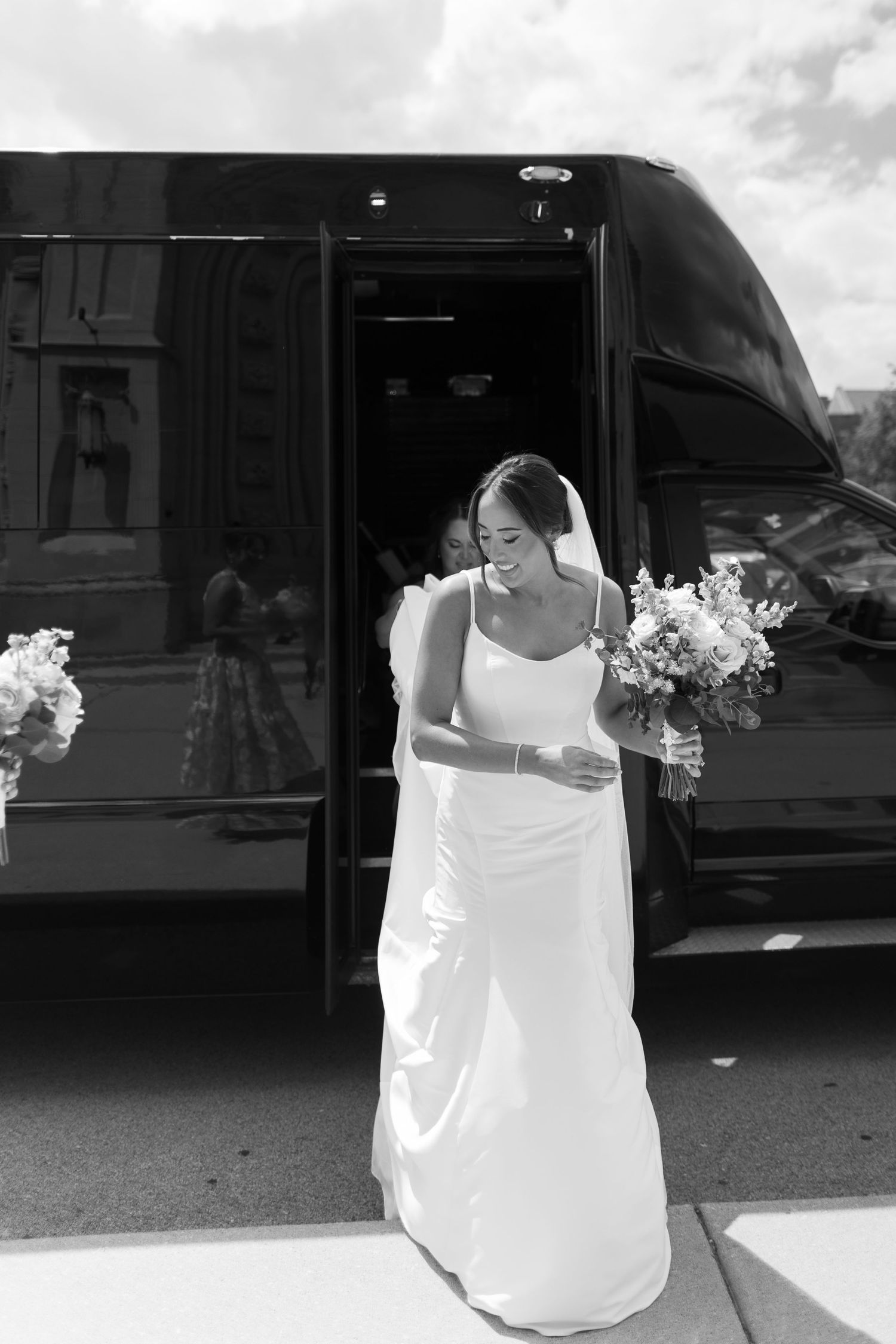 White bridal gowns on hangers in a black and white photograph.