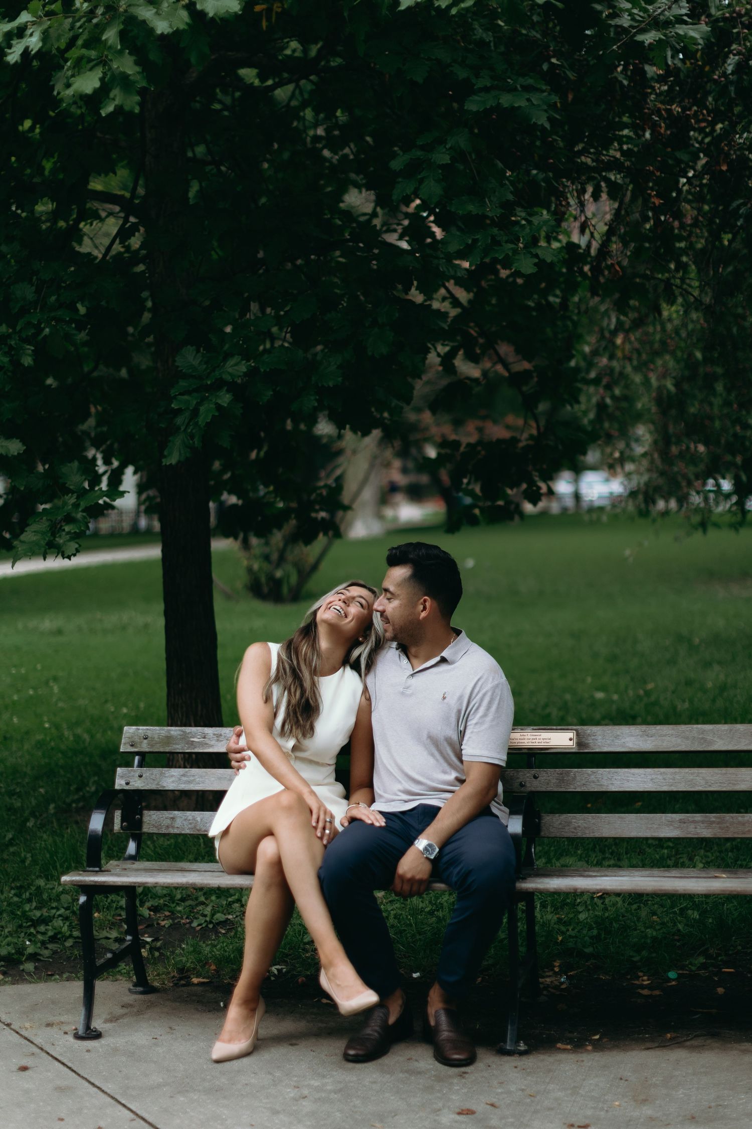 Romantic couple sharing intimate moment on park bench in green setting. The Gold Coast Engagement photos