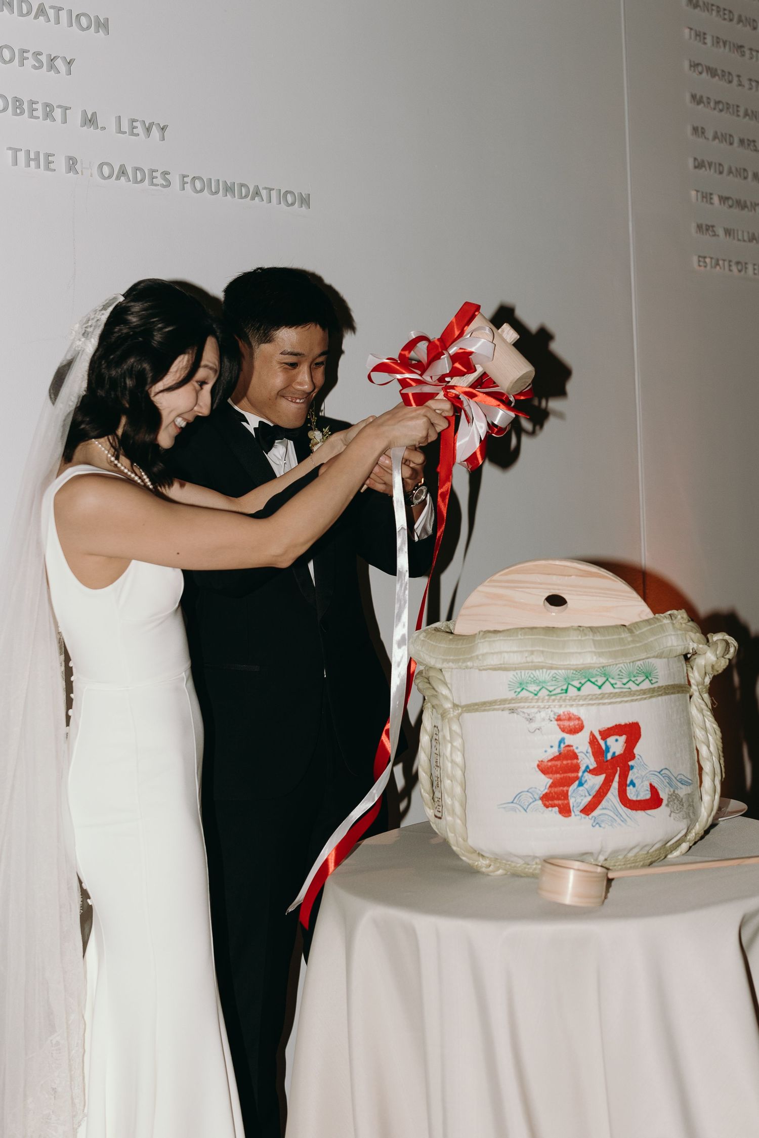 Wedding celebration moment with guests gathered around a decorated ceramic jar centerpiece.