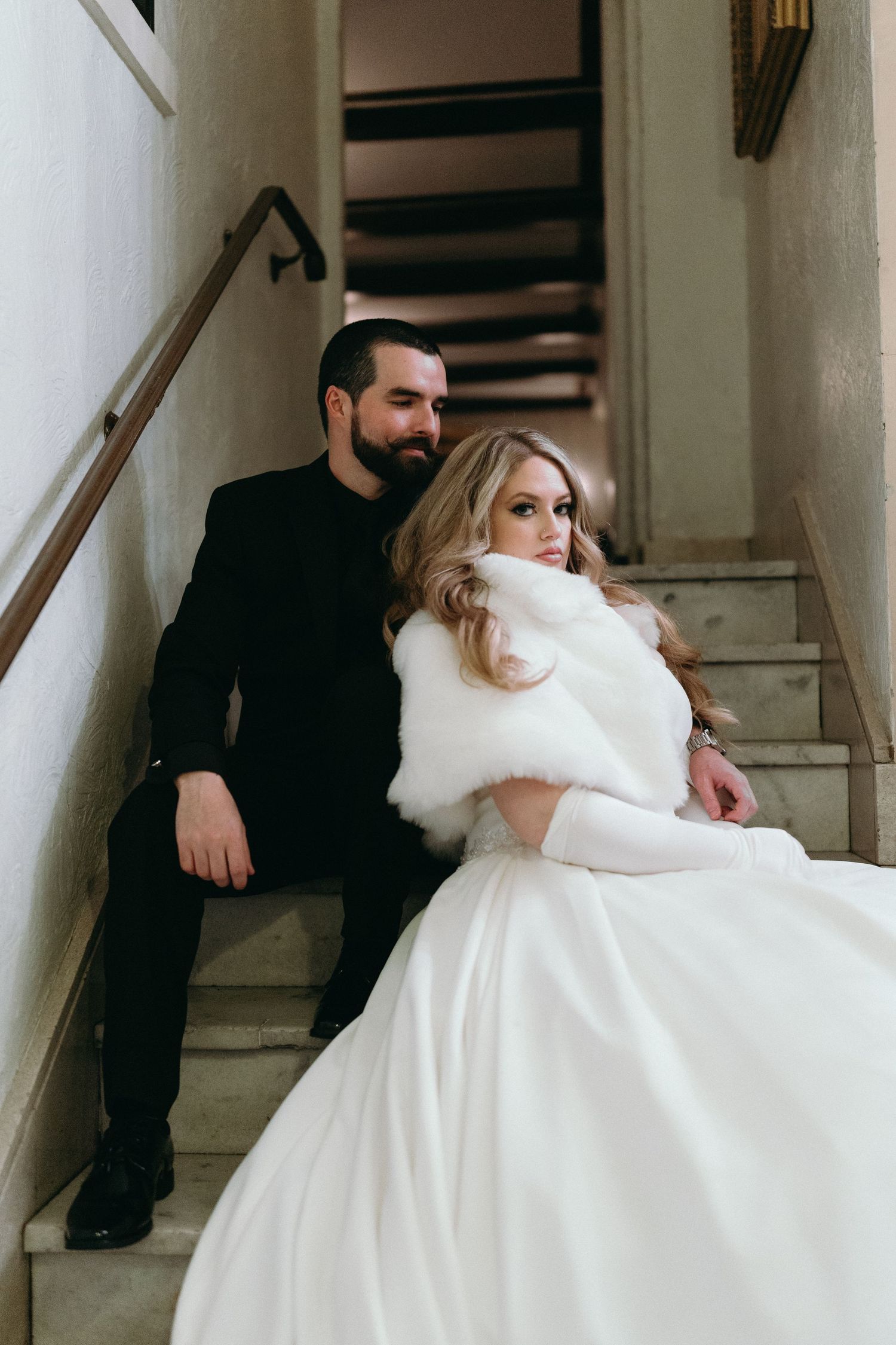 Couple shares intimate moment on staircase at winter wedding.