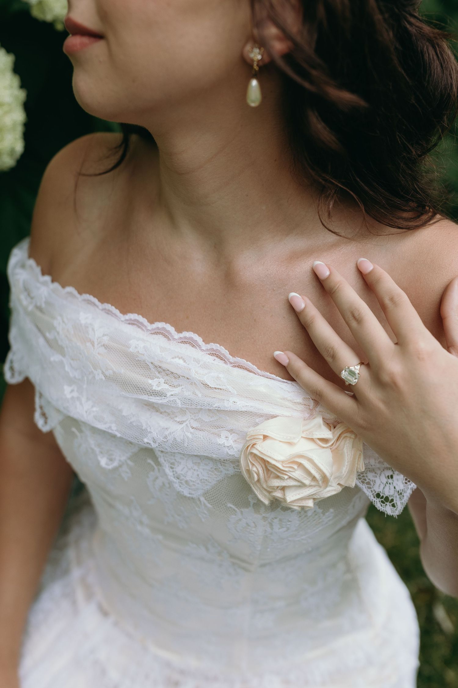 A series of close-up shots showing delicate white lace details and fabric flower embellishments on a wedding dress.