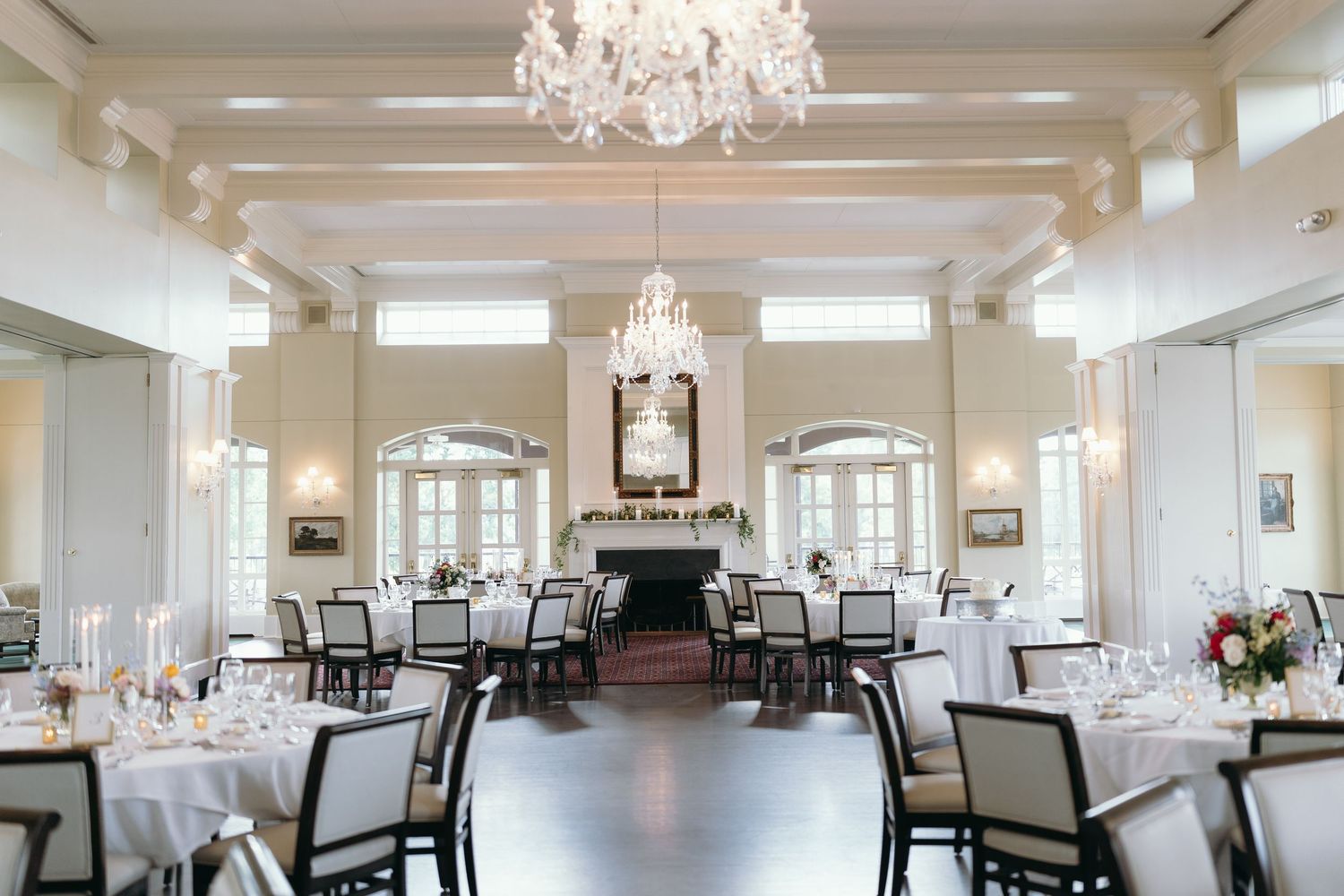 Elegant ballroom with crystal chandeliers set for wedding reception.