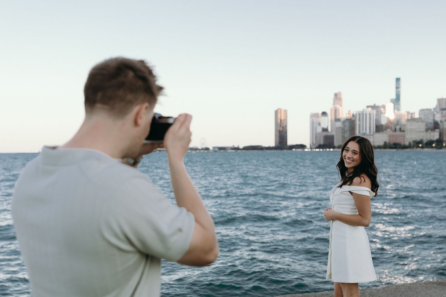A series of photos showing people taking pictures of the Chicago skyline from the waterfront on a sunny day.
