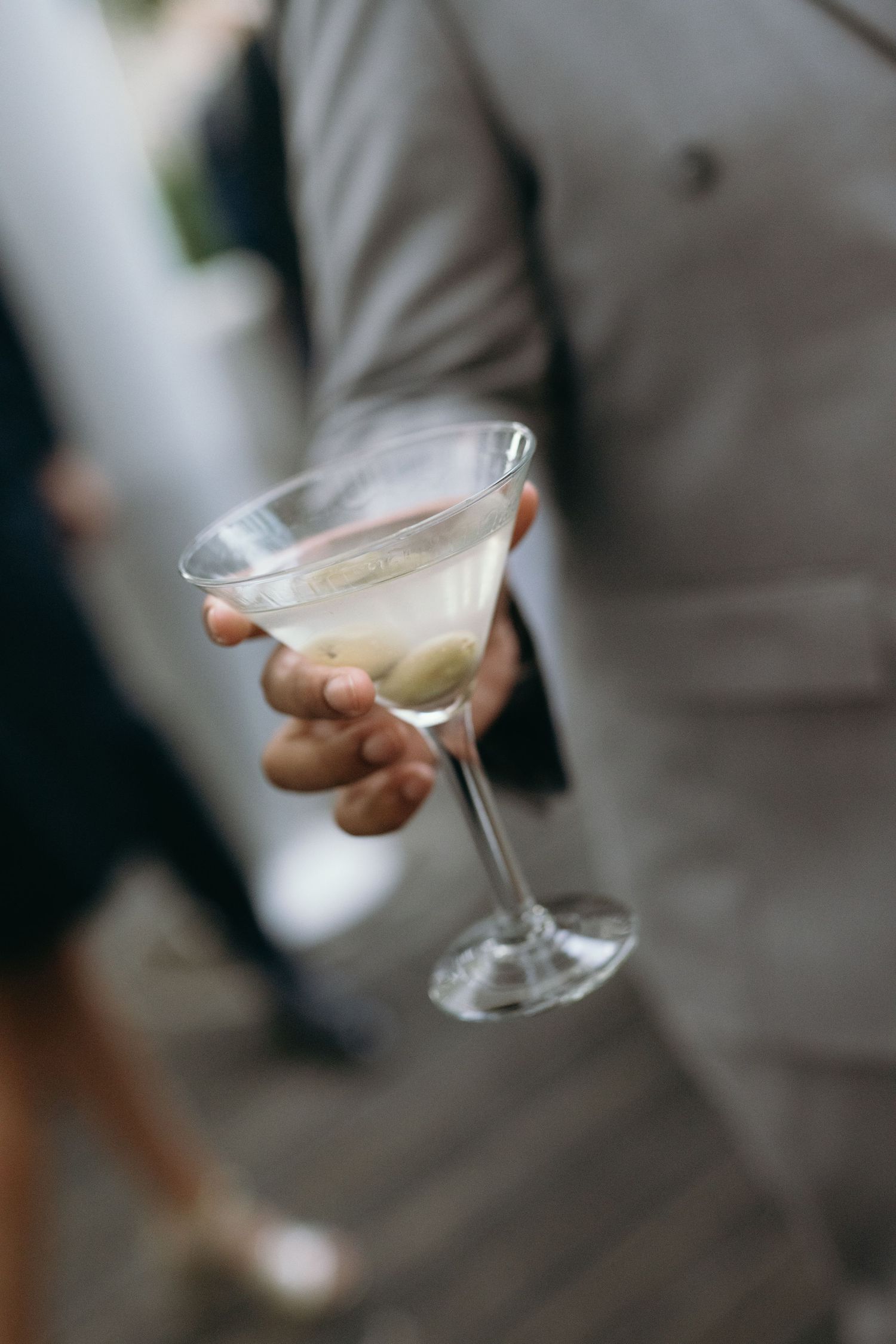 Hand holding a chilled martini glass with a classic cocktail.