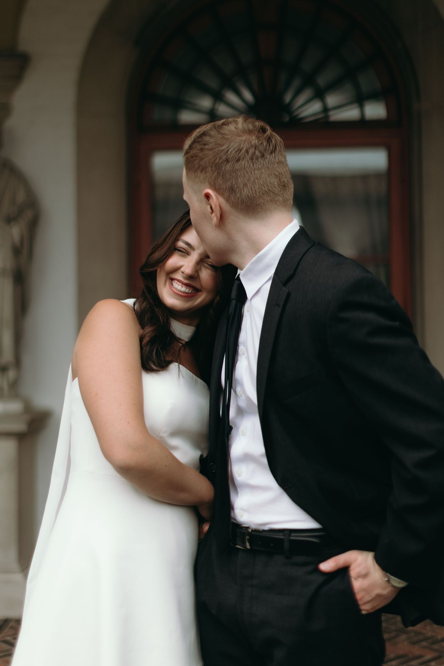 A romantic wedding couple shares tender kisses in a sequence of black and white photographs.