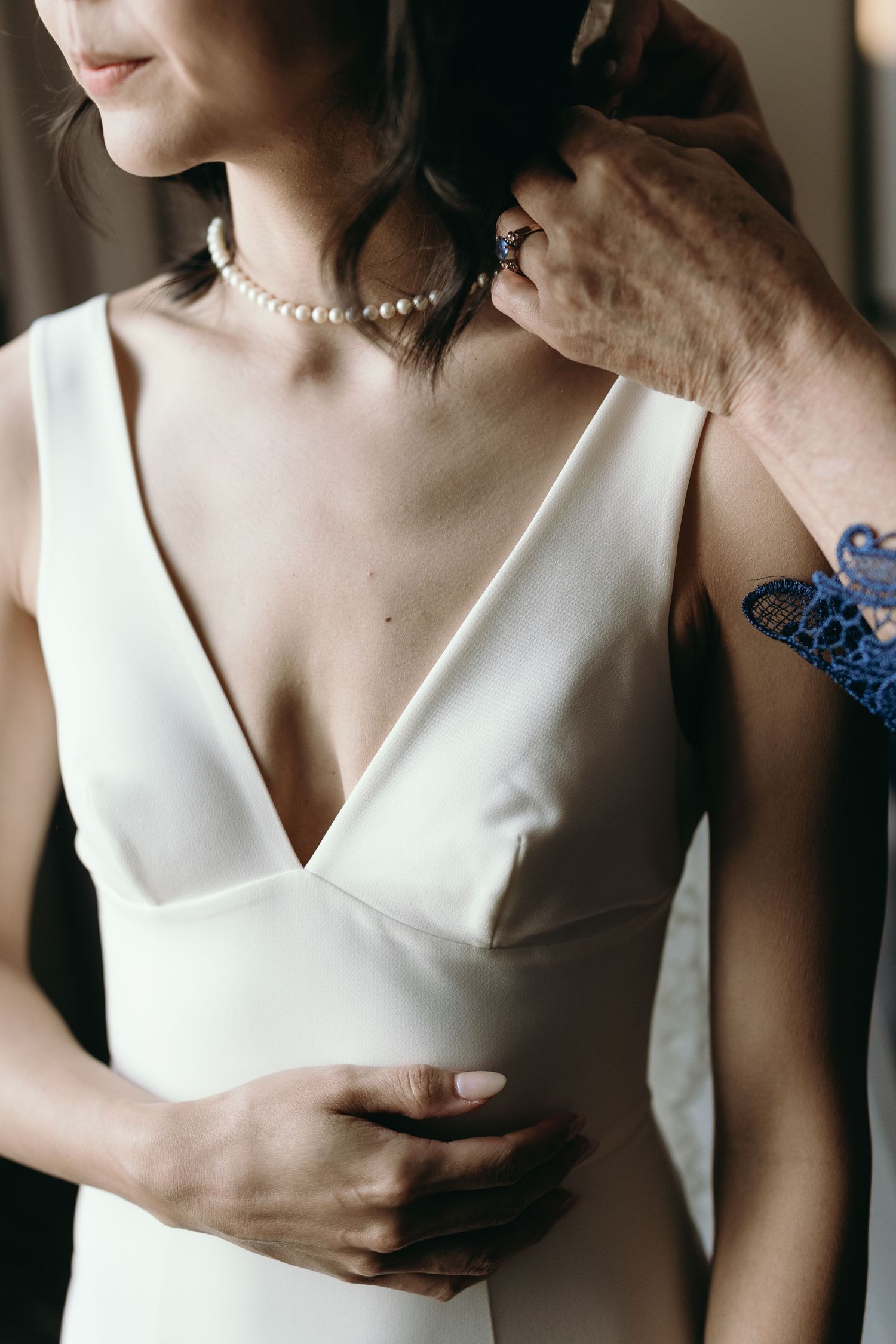 Close-up detail of an elegant white wedding dress with v-neckline.