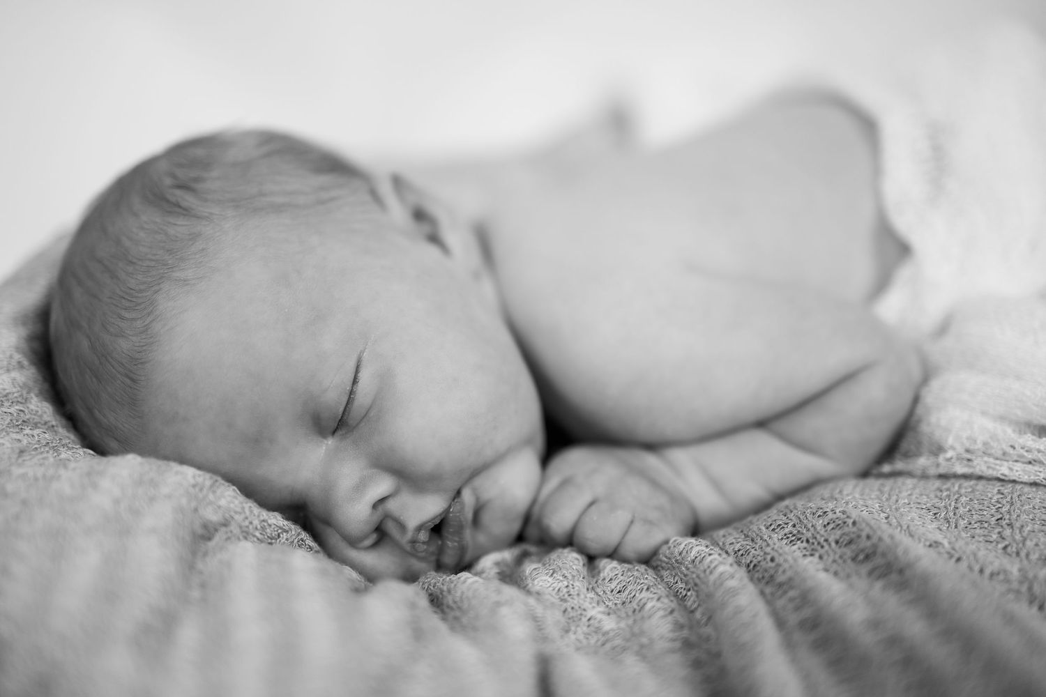 Peaceful sleeping newborn baby in black and white portrait.