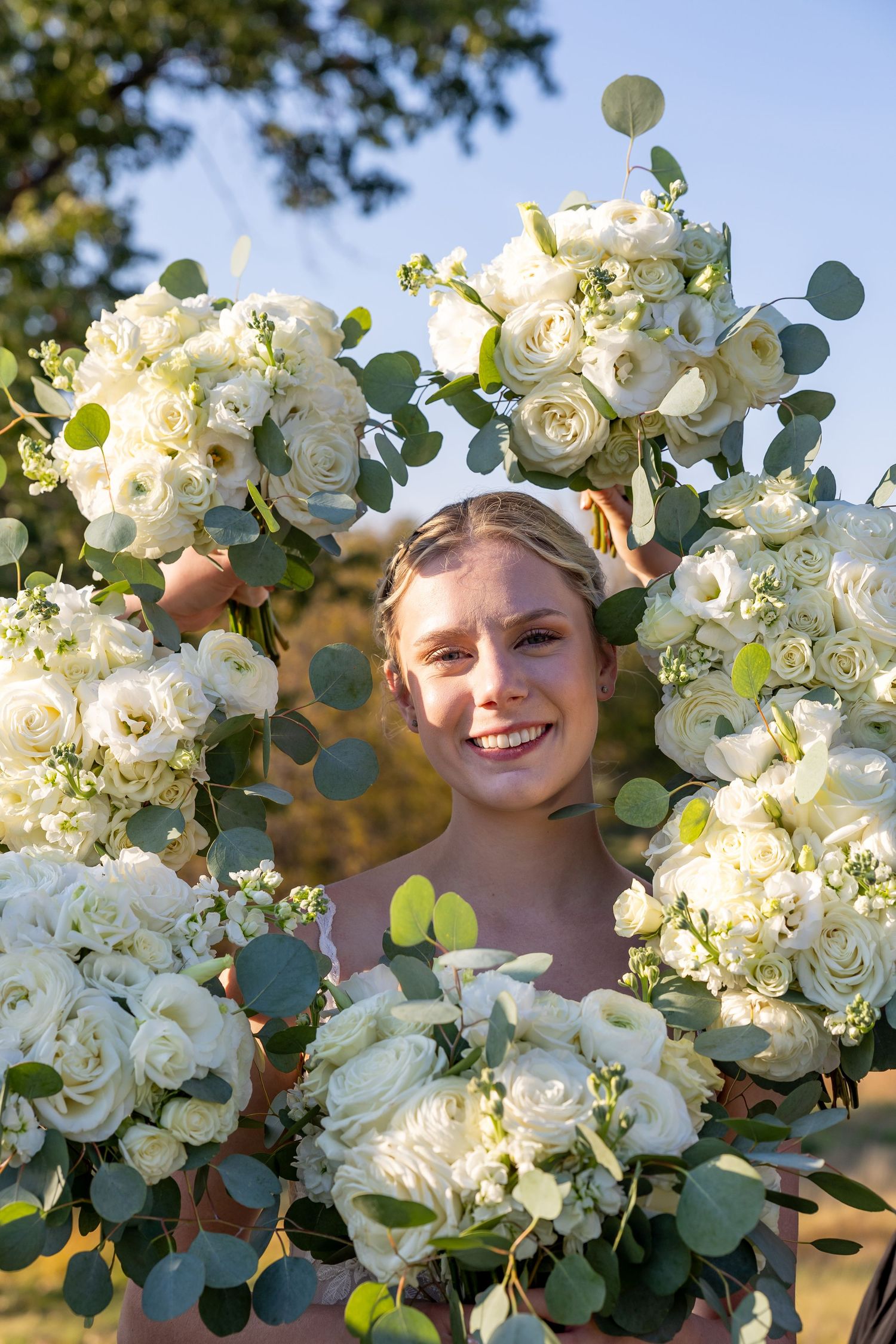 Beautiful white rose and eucalyptus bouquets arranged in a natural outdoor setting.