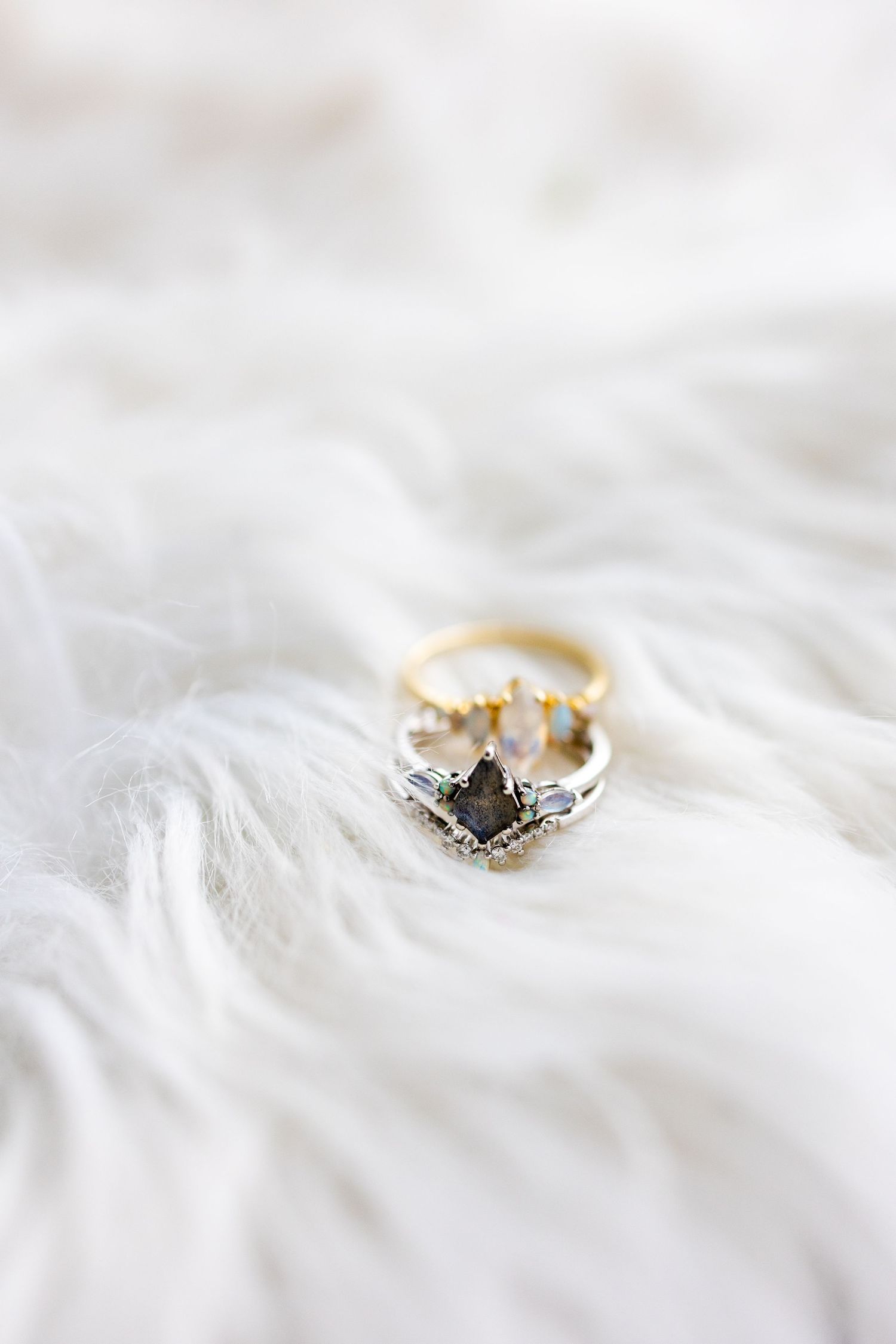 Close-up shots of a delicate engagement ring with diamonds on white fabric.