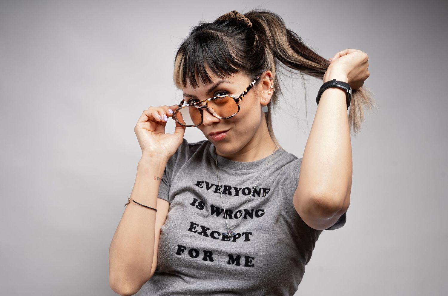Person in glasses and gray t-shirt with text message posing in multiple artistic studio shots.