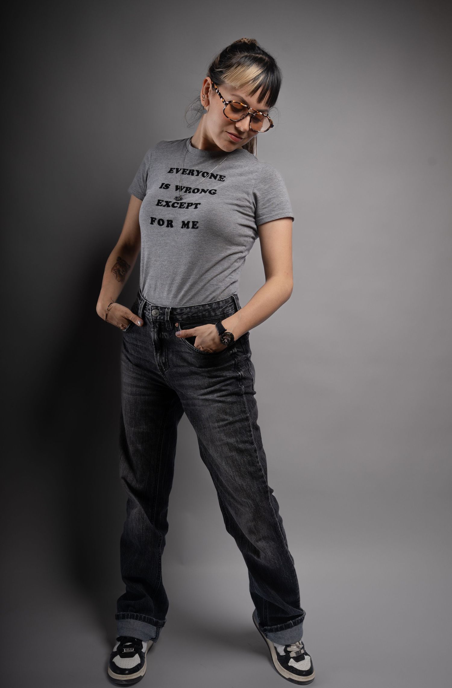 A person in a gray t-shirt and jeans strikes various casual poses against a dark background.