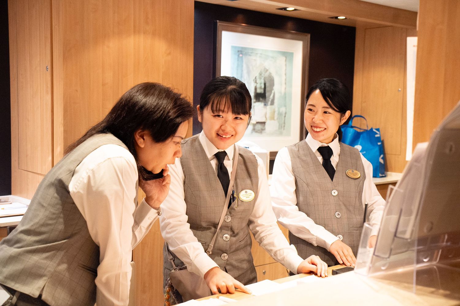 Group of staff members collaborating at desk in office with wooden interior.