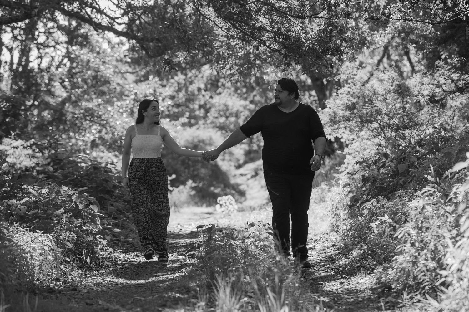 A series of black and white photos showing people walking along a scenic mountain trail.