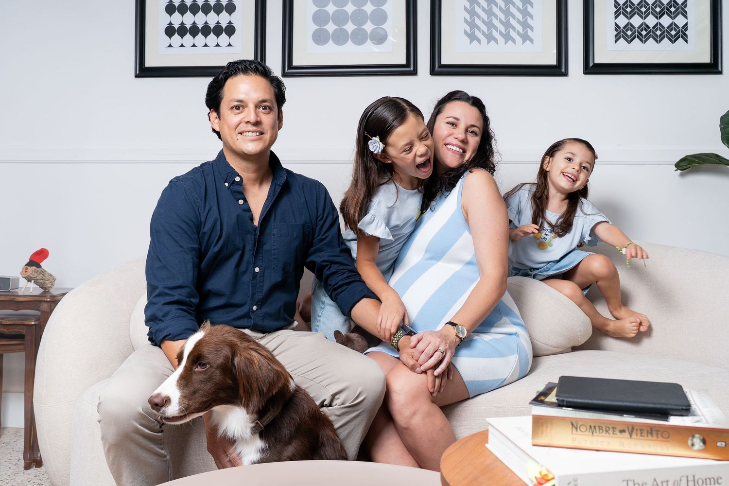 Modern family portrait session with minimalist decor and black and white artwork.