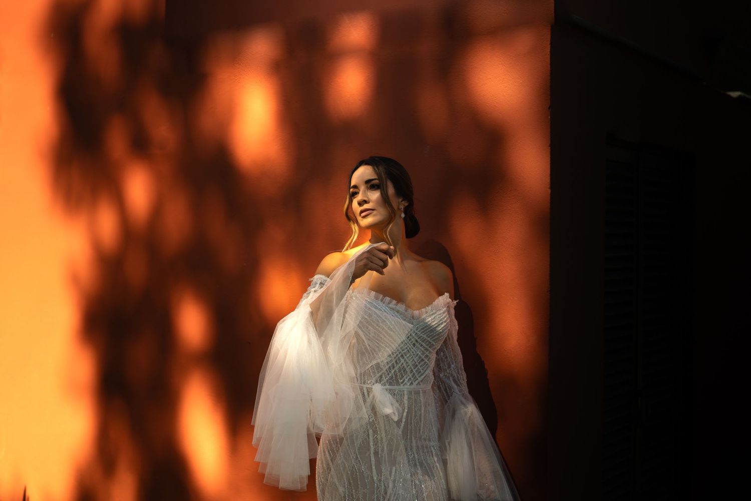 A warm orange-tinted portrait with soft lighting and dreamy bokeh effects in the background.