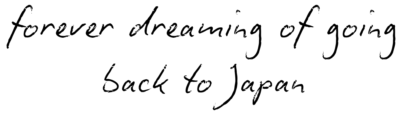 Handwritten text on white paper reads 'forever dreaming of going back to Japan' in cursive script.
