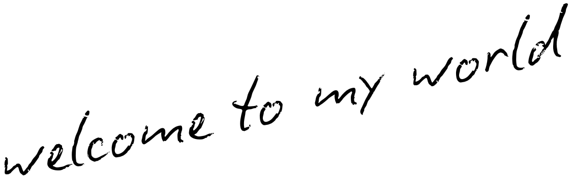 Handwritten cursive text reads 'welcome to my world' in black ink on white paper.