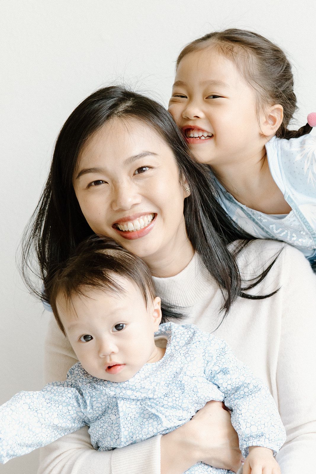 Four candid photos showing joyful moments between a parent and child in matching white and blue outfits.
