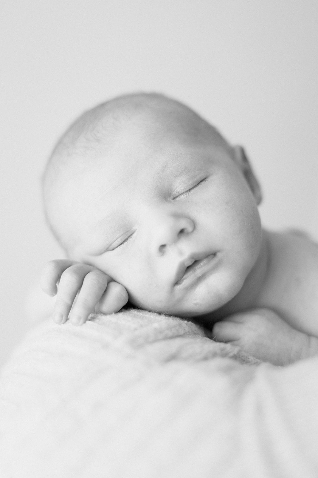 Artistic black and white close-up portraits of a sleeping newborn baby.