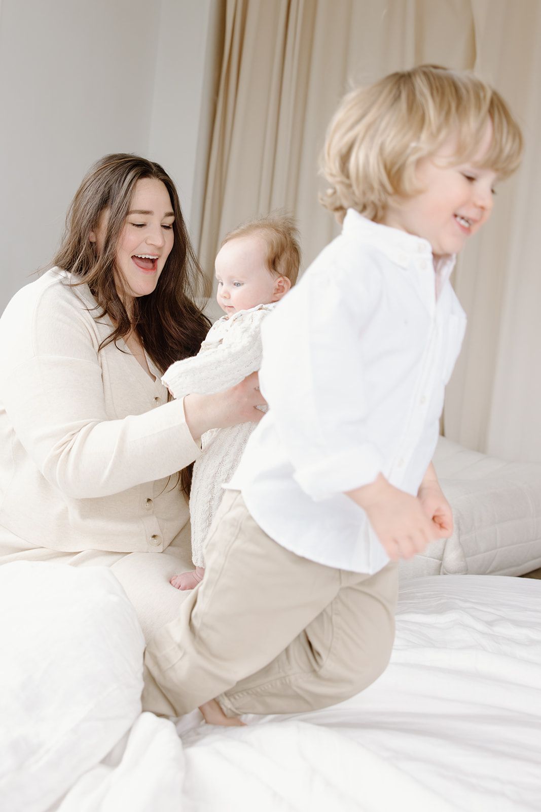 A playful moment captured between two people on a bright white bed.