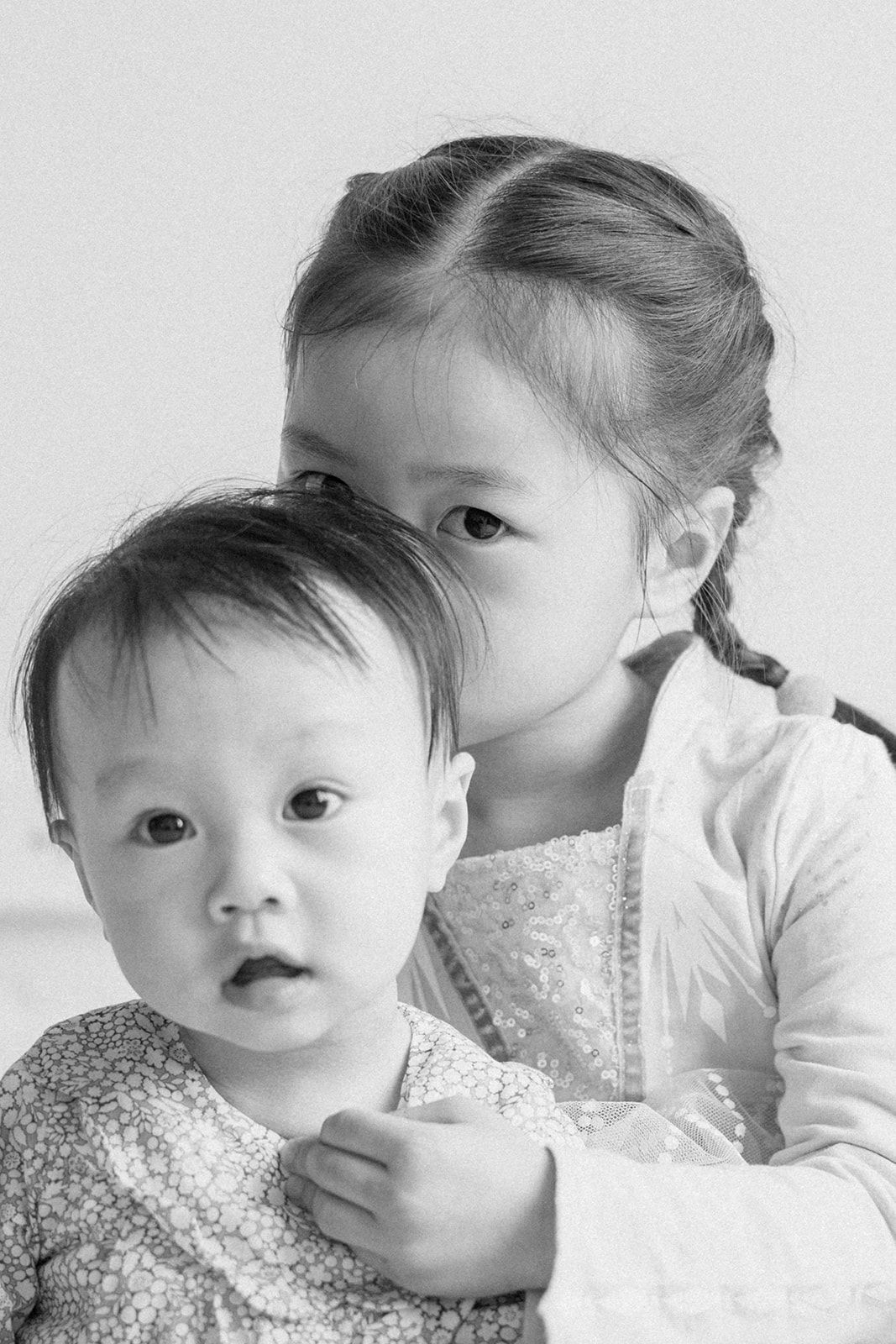 Black and white photo series showing expressive closeup portraits of a toddler making various playful faces.