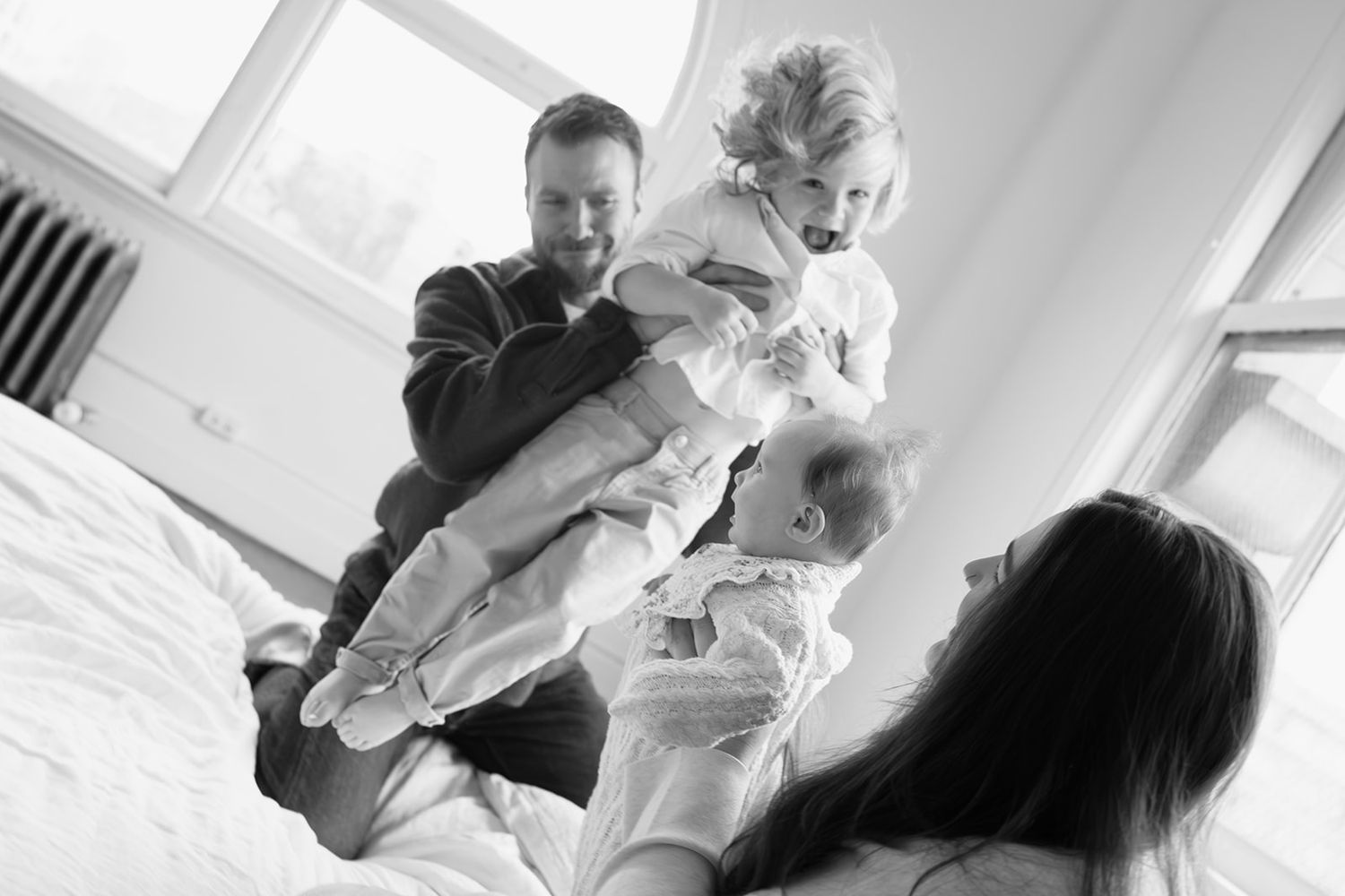 A candid black and white family moment captured in a bright room.