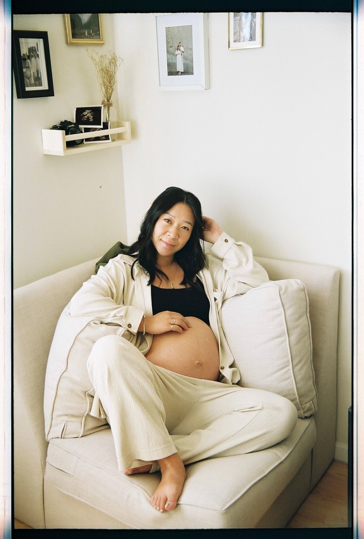 A person lounges comfortably in a white couch, wearing casual beige clothing in a minimalist living room setting.