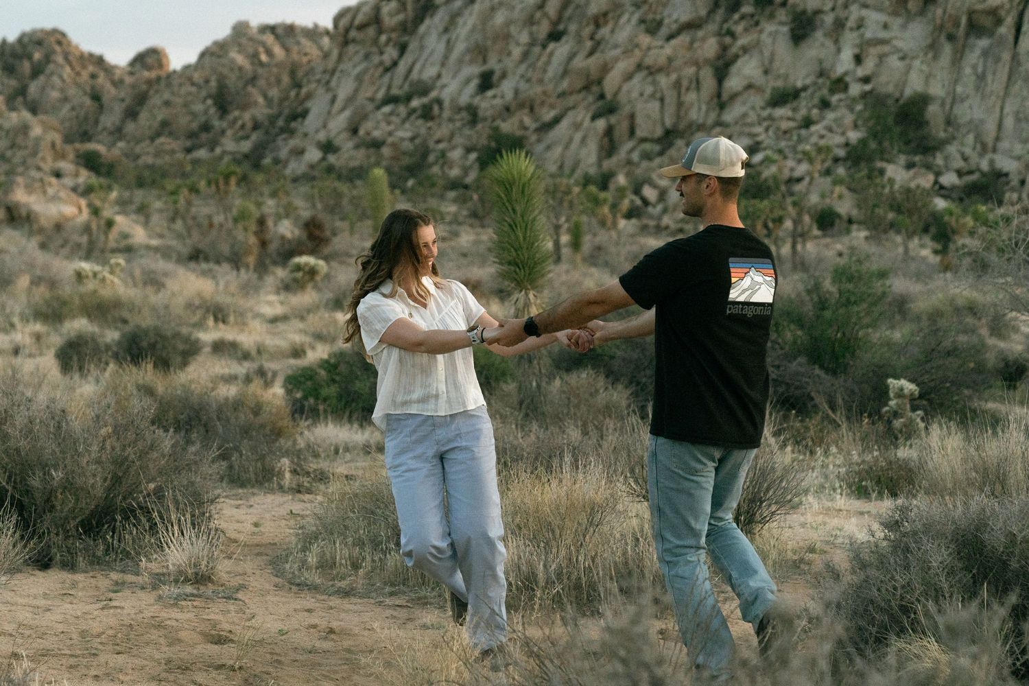 Two people walk together through Joshua Tree National Park.