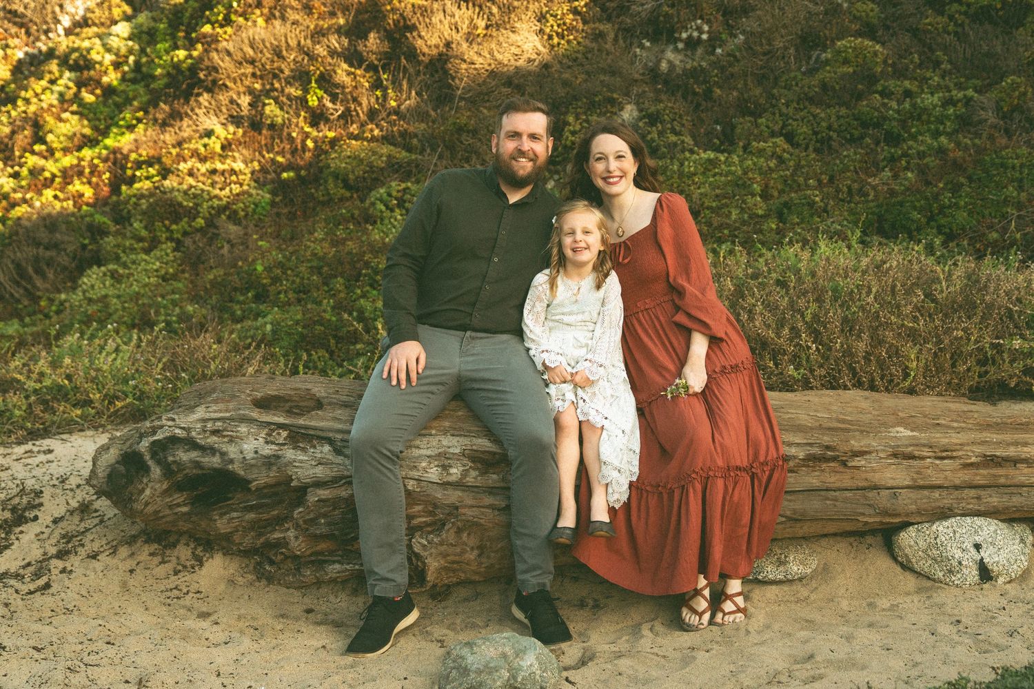 Family enjoying a scenic autumn photoshoot outdoors with golden foliage in the background.