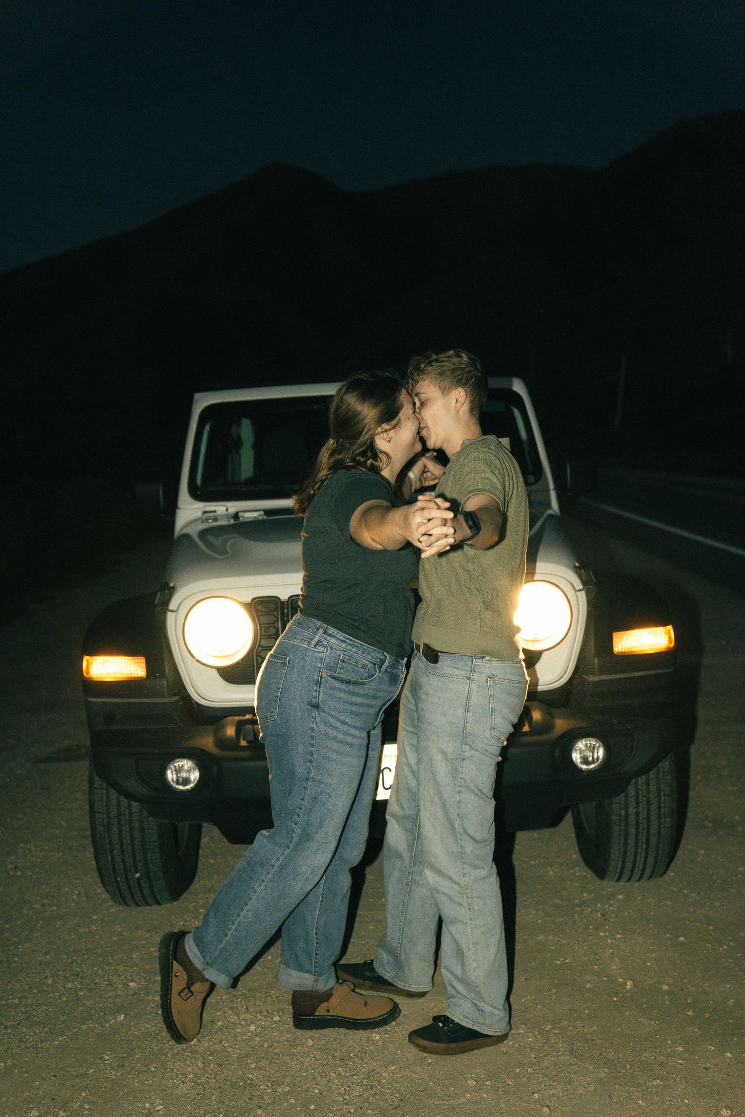 Couple posing in front of the off road car along Big Sur.