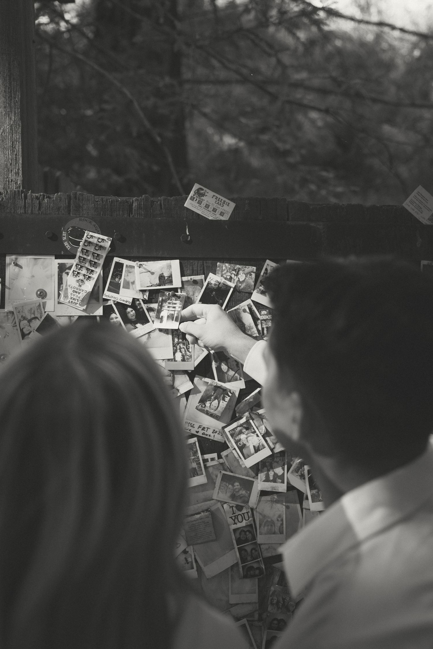 A wall covered in vintage black and white photographs displayed in a collage style arrangement.