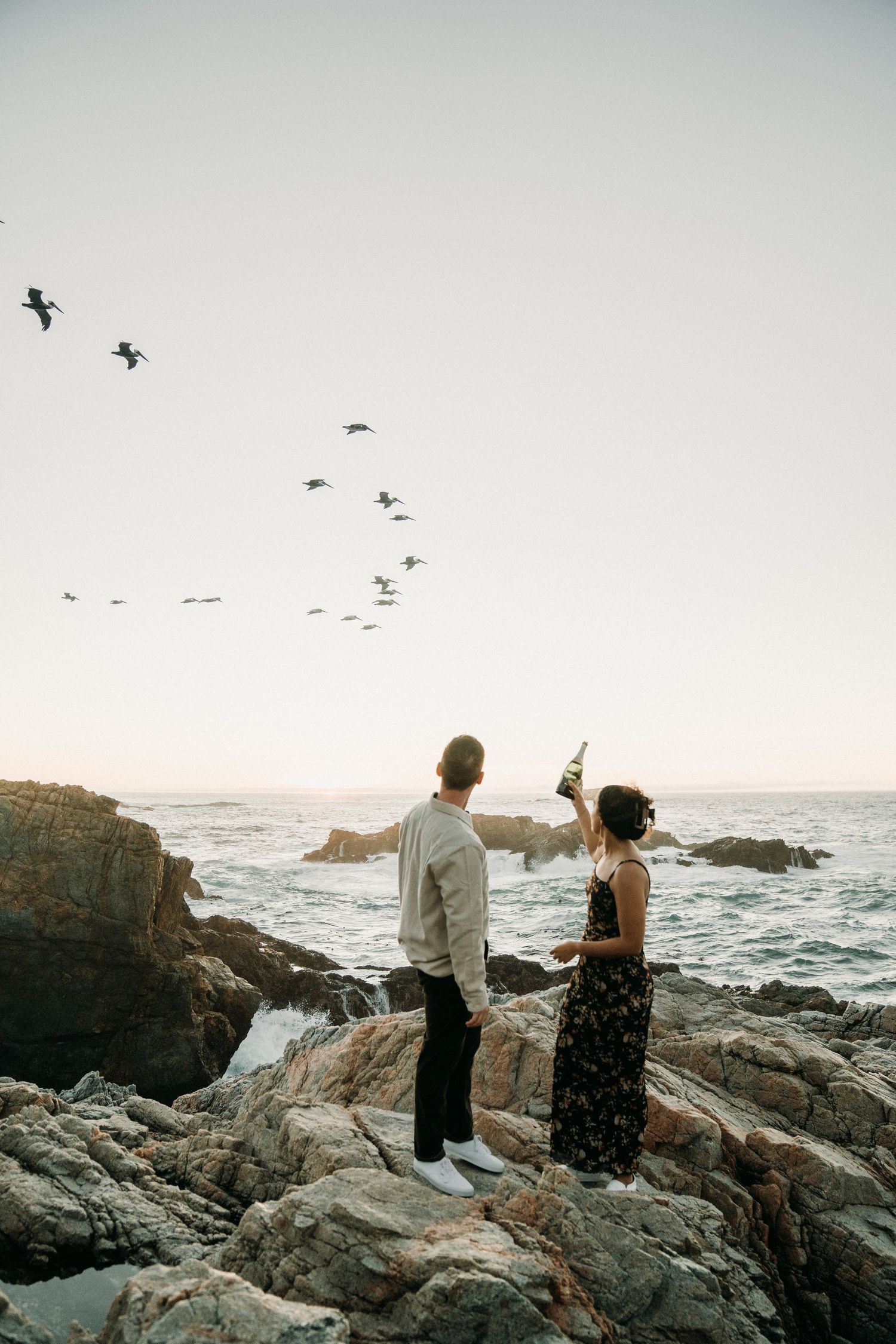 Couple watches birds on the cliffs of Big Sur.