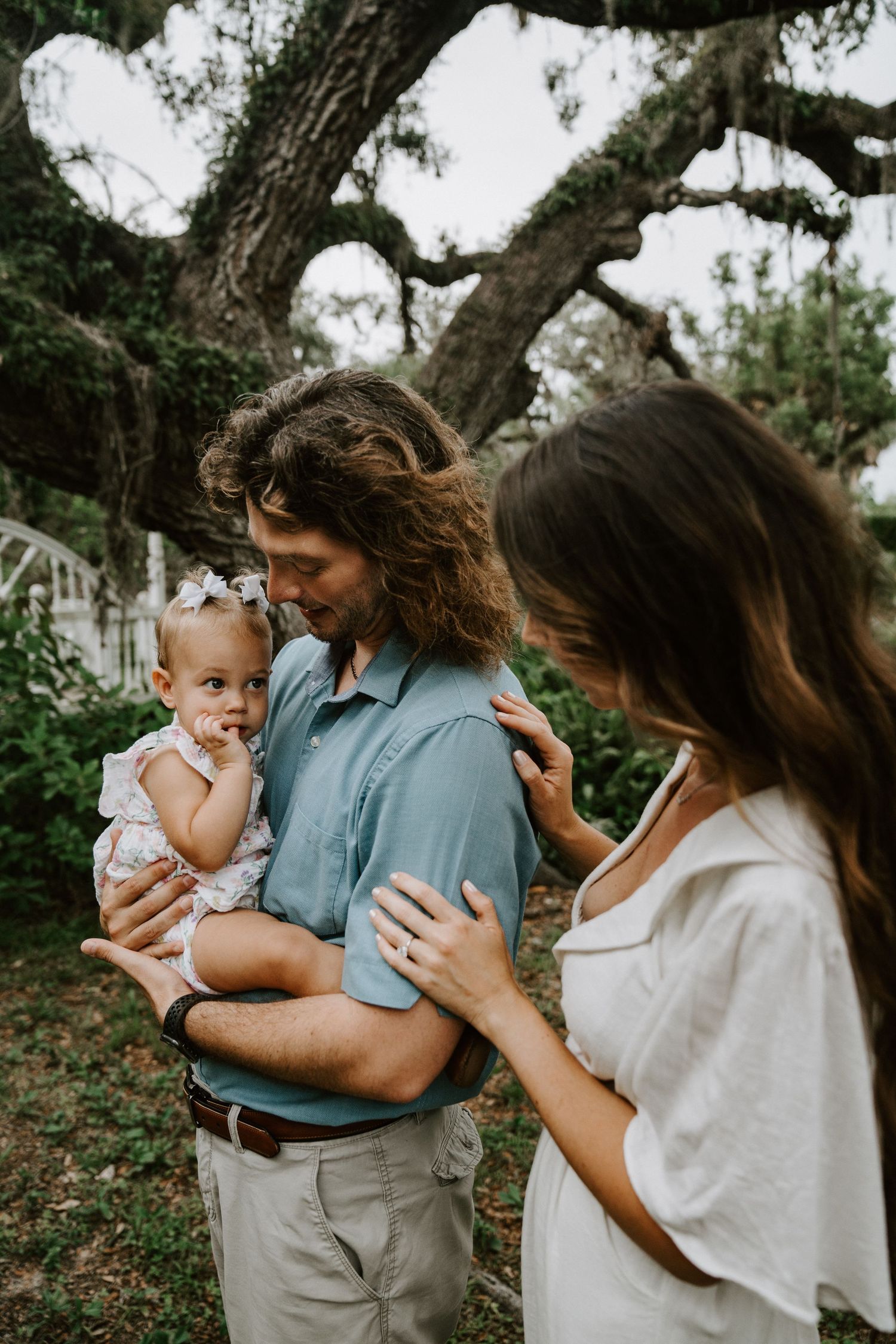 A heartwarming outdoor family portrait under a large oak tree.