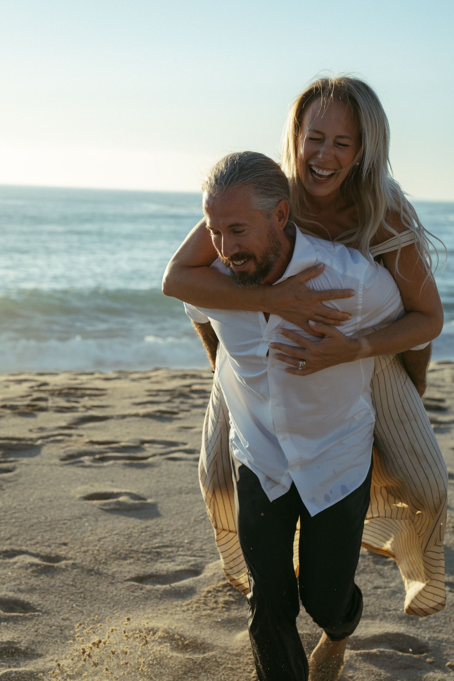 A romantic sequence of playful piggyback ride moments on a sunny beach.