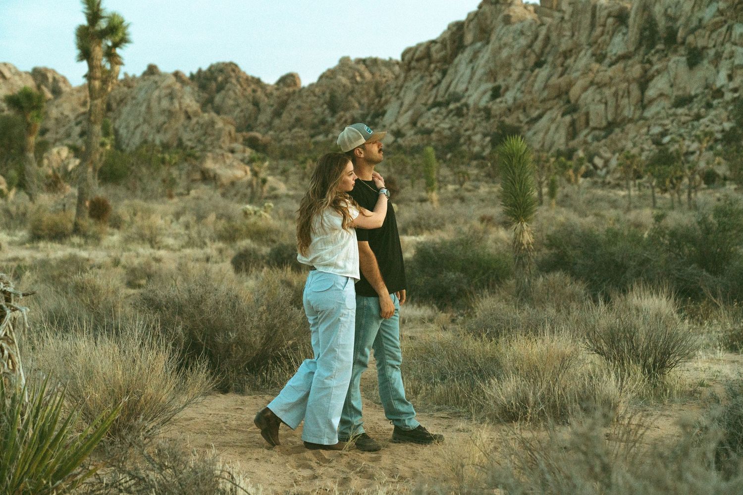 People walking together through scenic desert terrain with mountains in the background.