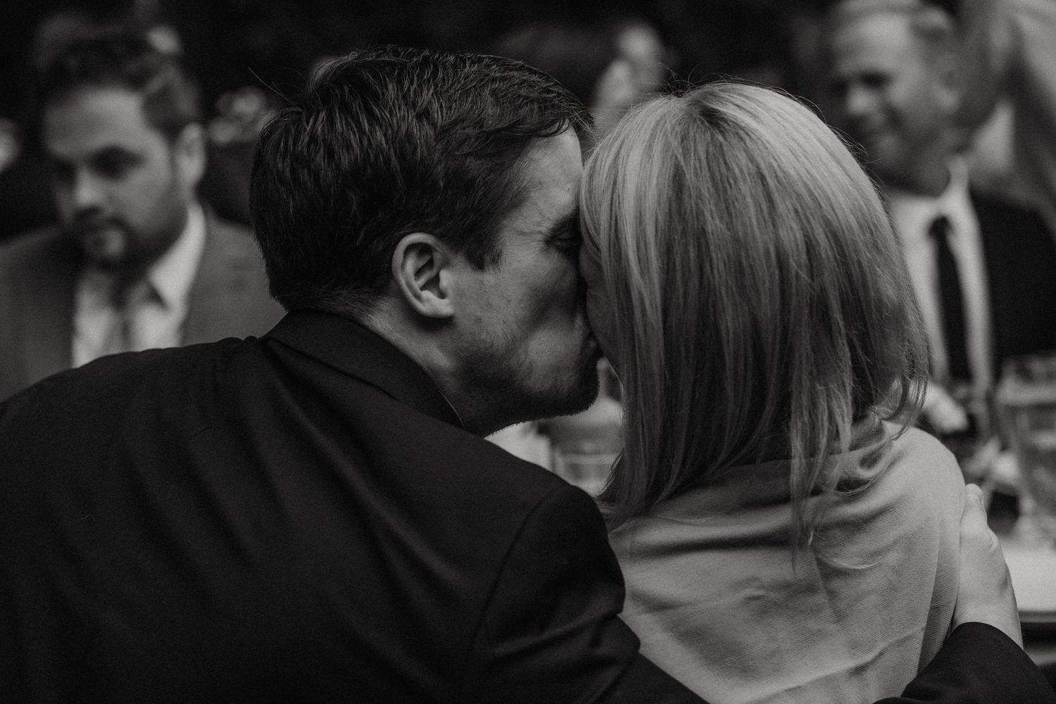 Black and white wedding photo sequence showing a couple's first dance at their reception and a tender kiss.