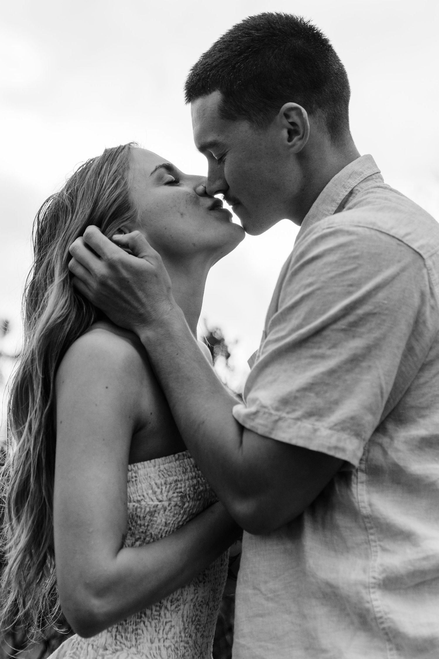 A romantic black and white portrait of a couple in an intimate embrace about to kiss in Big Sur California.