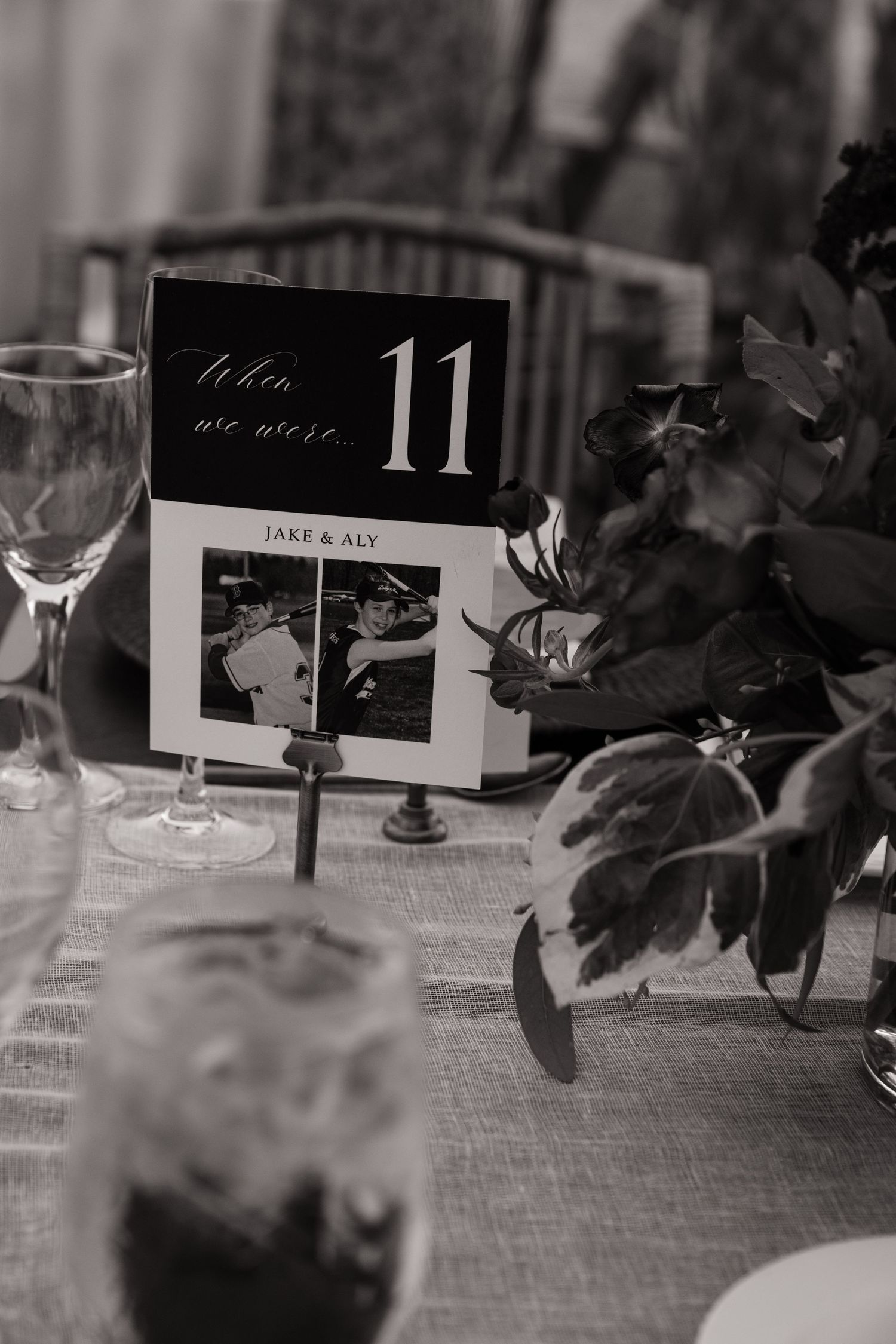 Black and white detail shot of wedding reception table numbers and name cards.