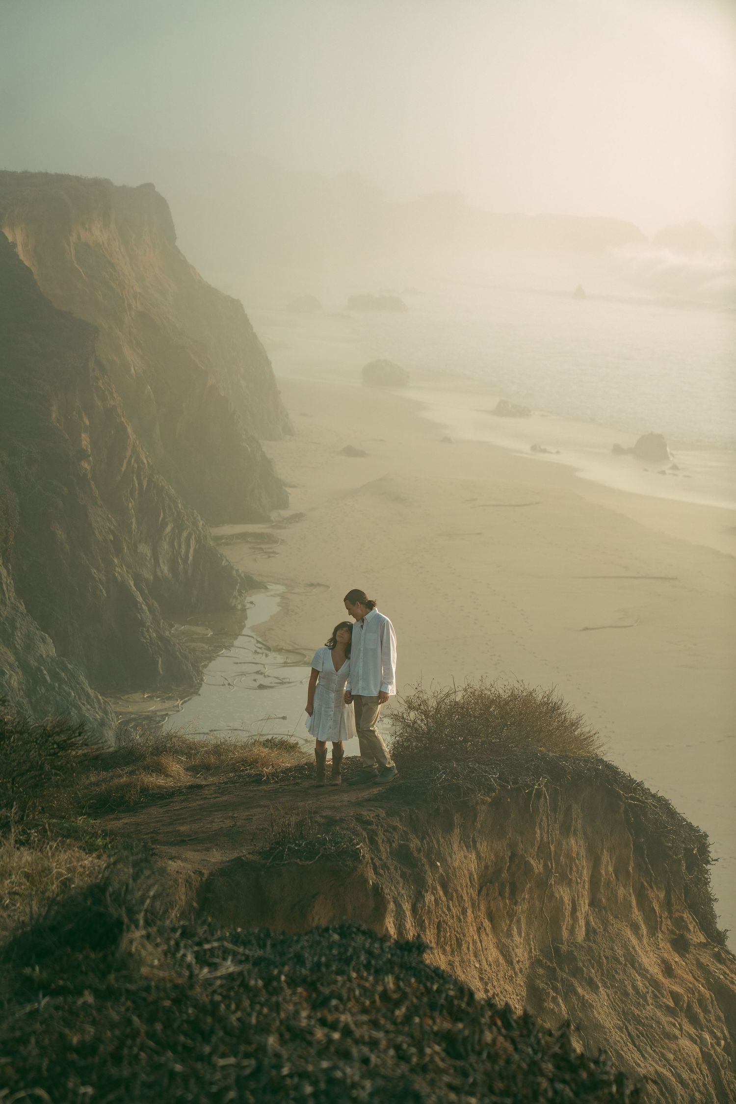 elopement couple embraces along the beach of Big Sur