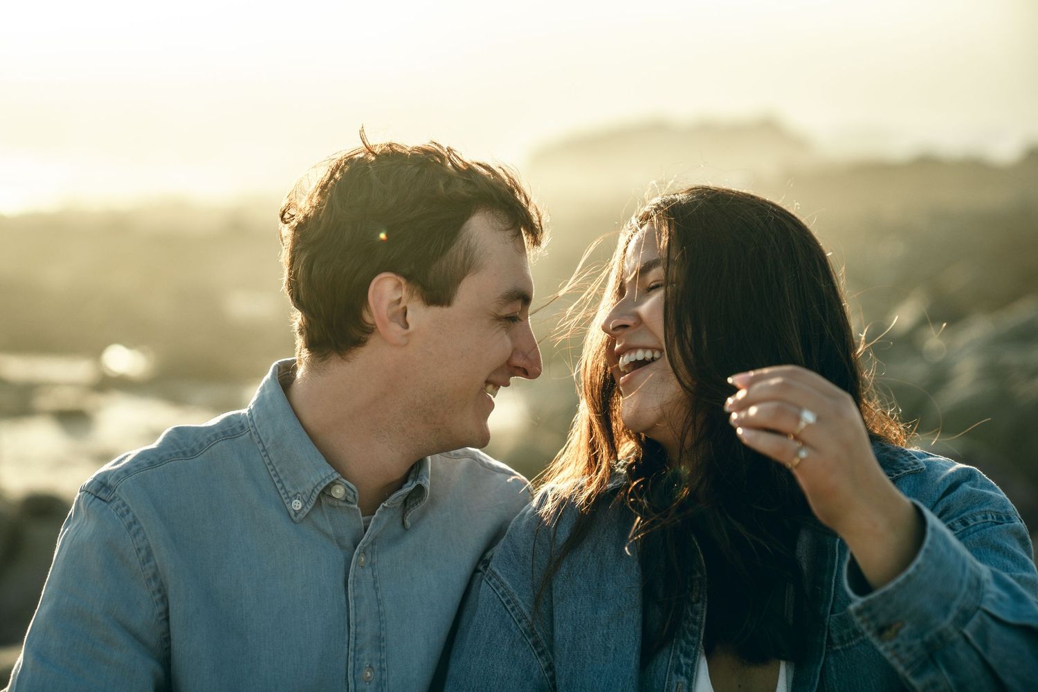 Intimate couple moments captured against coastal sunset backdrop.