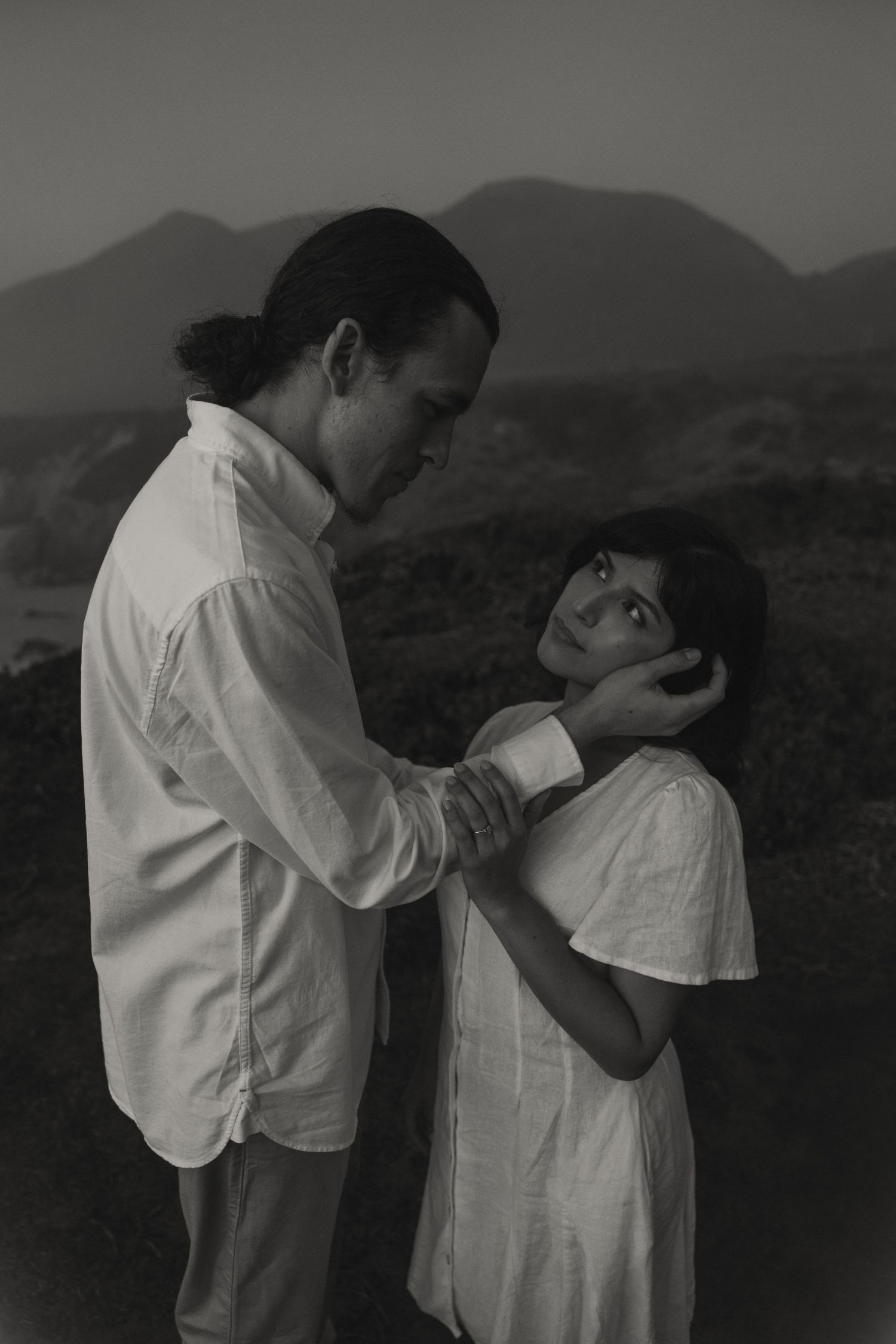 A dramatic black and white series showing a couple's intimate dance poses against a mountain landscape.