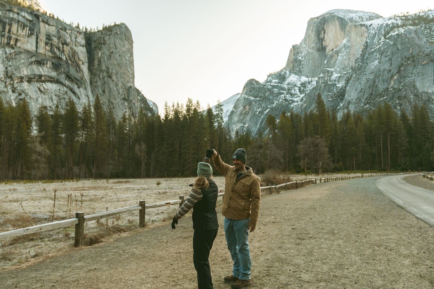 Two people enjoying a winter walk along a path in Yosemite National Park.