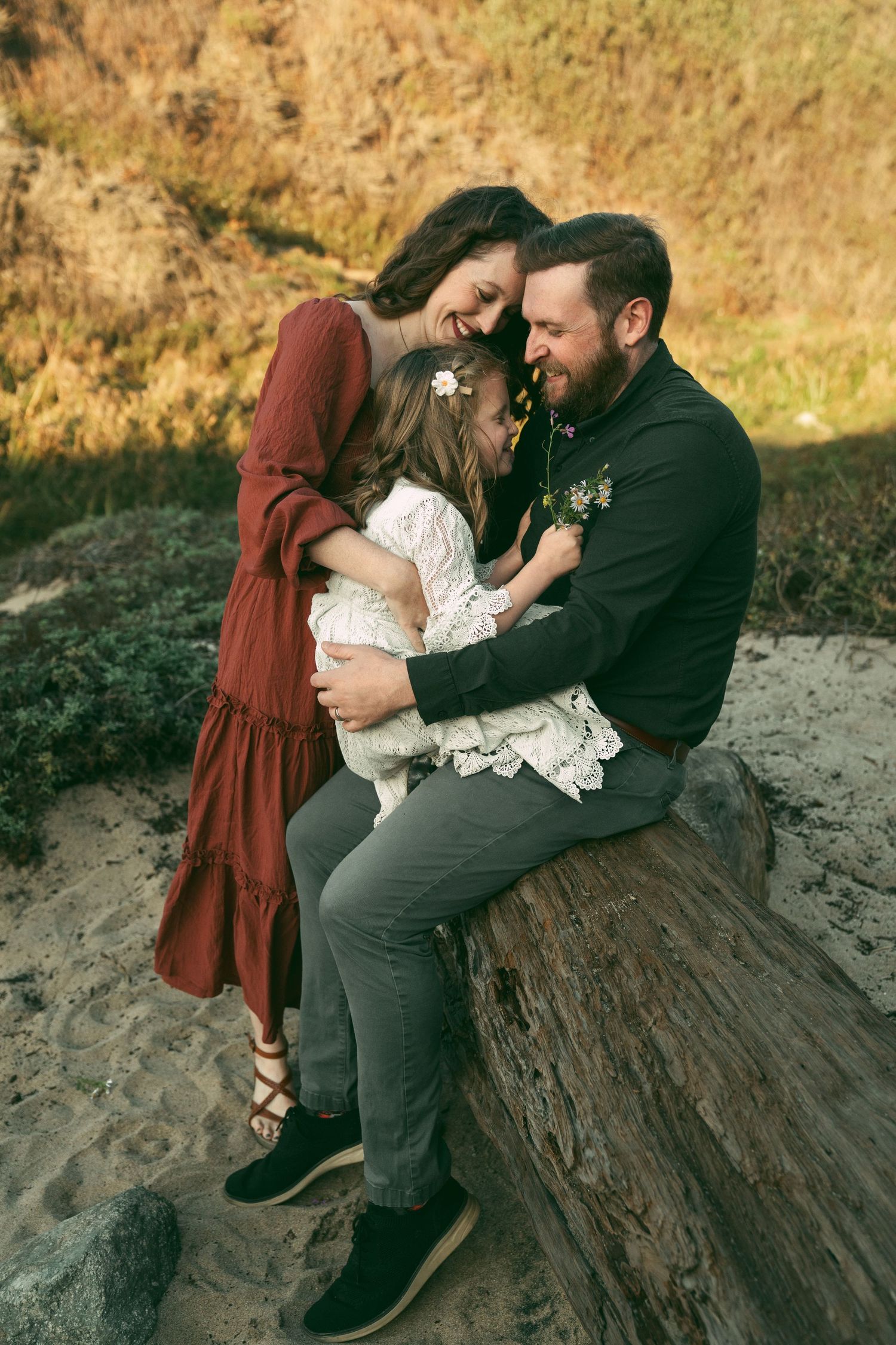 A couple shares intimate moments on a rocky beach during golden hour in autumn.