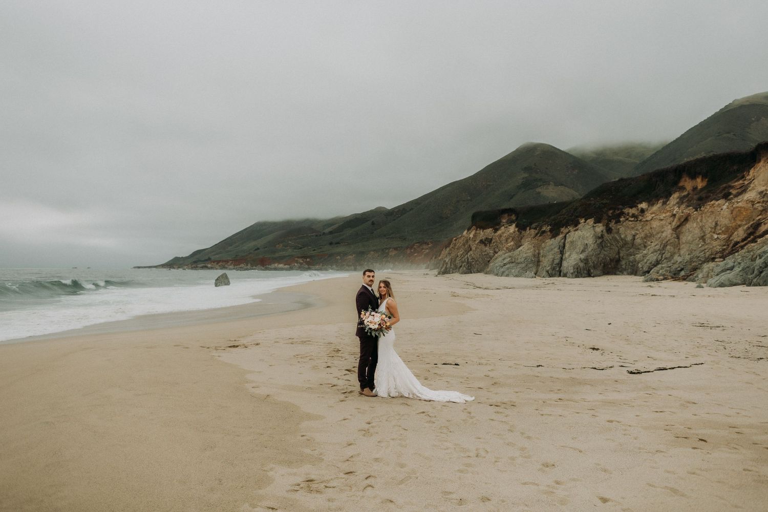 Misty coastal wedding photography session along a dramatic California beach.