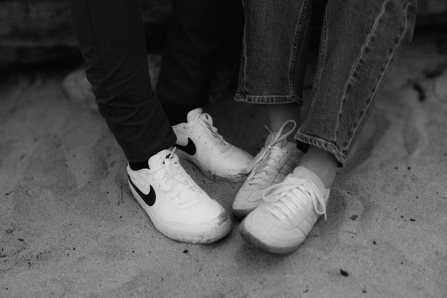 Black and white detail shot of shoes on a textured surface.