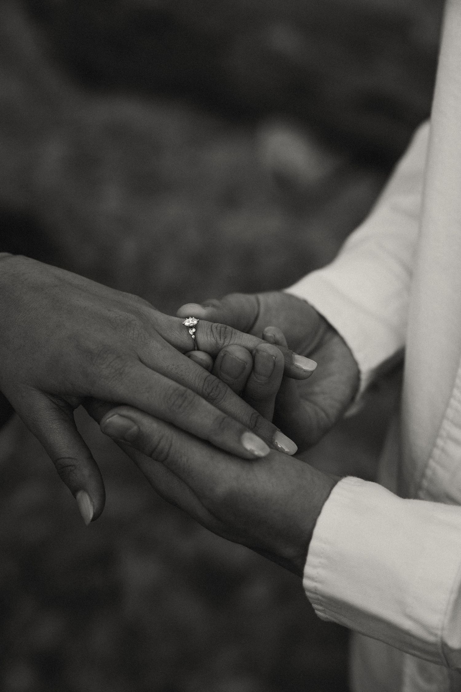 Close-up black and white photos showing hands gently touching and intertwining.
